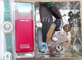 A tin of assorted items including a Swatch watch, Robertsons badges, an antique shell cameo brooch