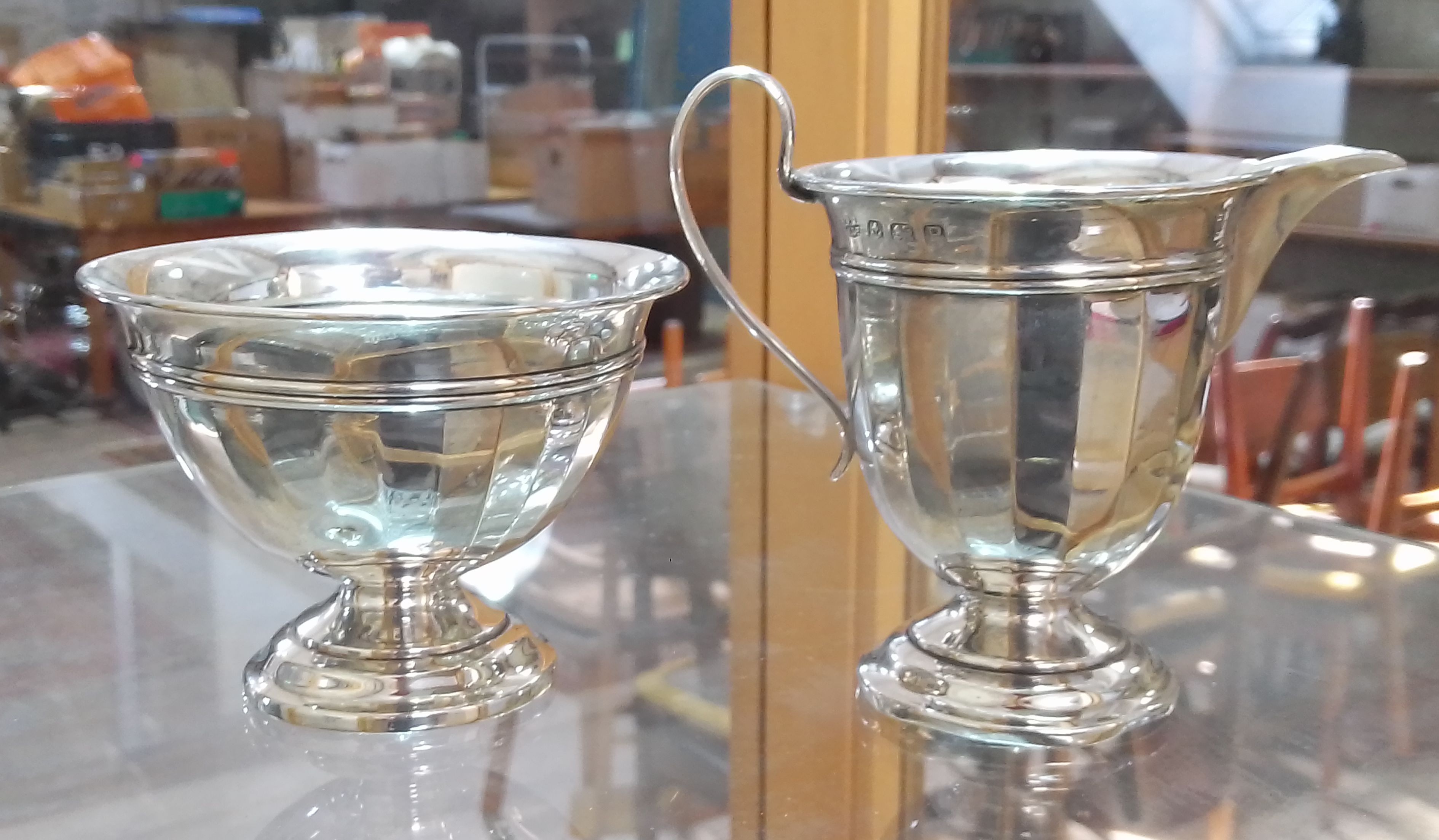 A hallmarked silver cream jug and sugar bowl, weight 3.7ozt. Condition - cream jug with dings to