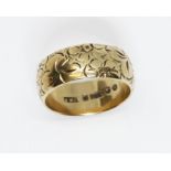 A hallmarked 9ct gold wedding band, outer edge with floral design, weight 7.4g, size R.