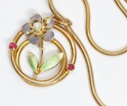 An early 20th century enamel pendant, floral design set with rubies, marked '15c', diameter 20mm,