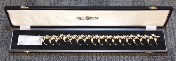 Brett Payne - an 18ct gold and silver necklace, cast silver links with flowers (some) marked '