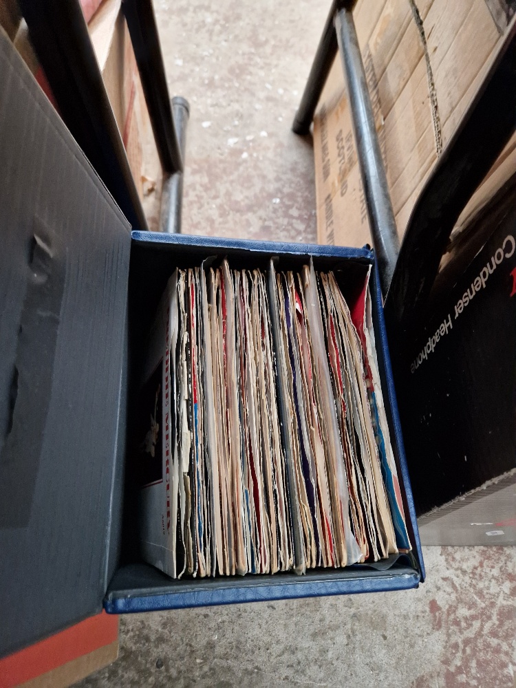 A case of vinyl 7" singles, mostly Queen and Freddy Mercury.