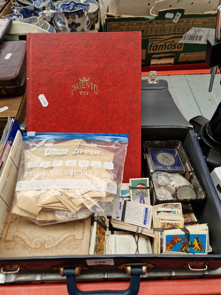 A case containing an album of world stamps, loose stamps, collector's cards, and coins.