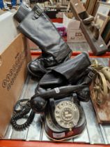 A black bakelite twist dial telephone and two pairs of vintage leather boots.