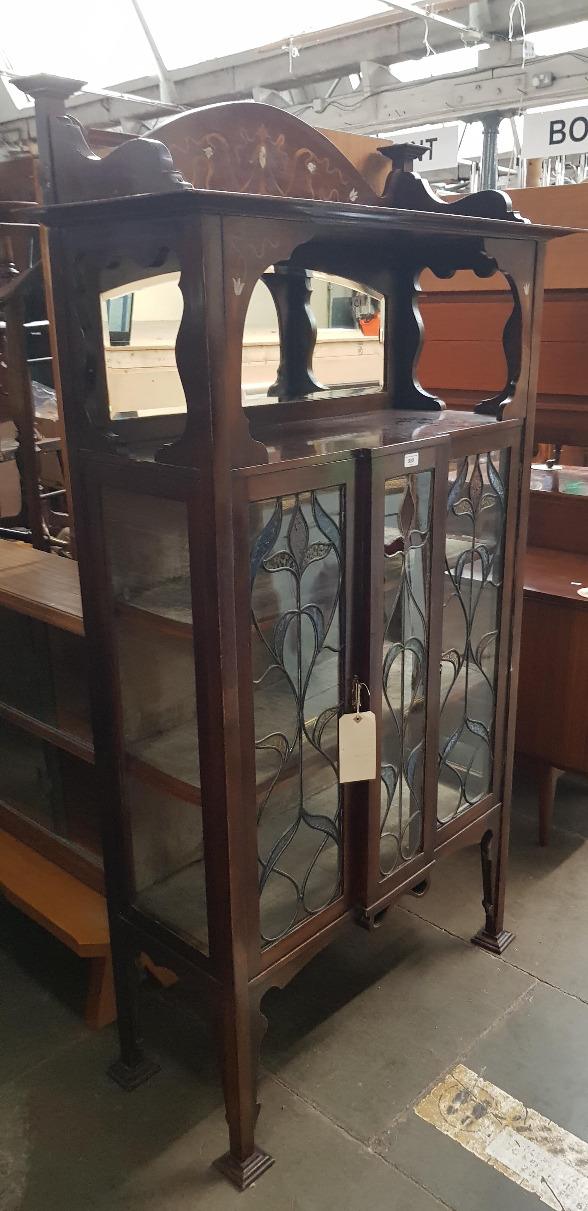 An Edwardian Arts & Crafts inlaid mahogany display cabinet with leaded glass panels to the doors.