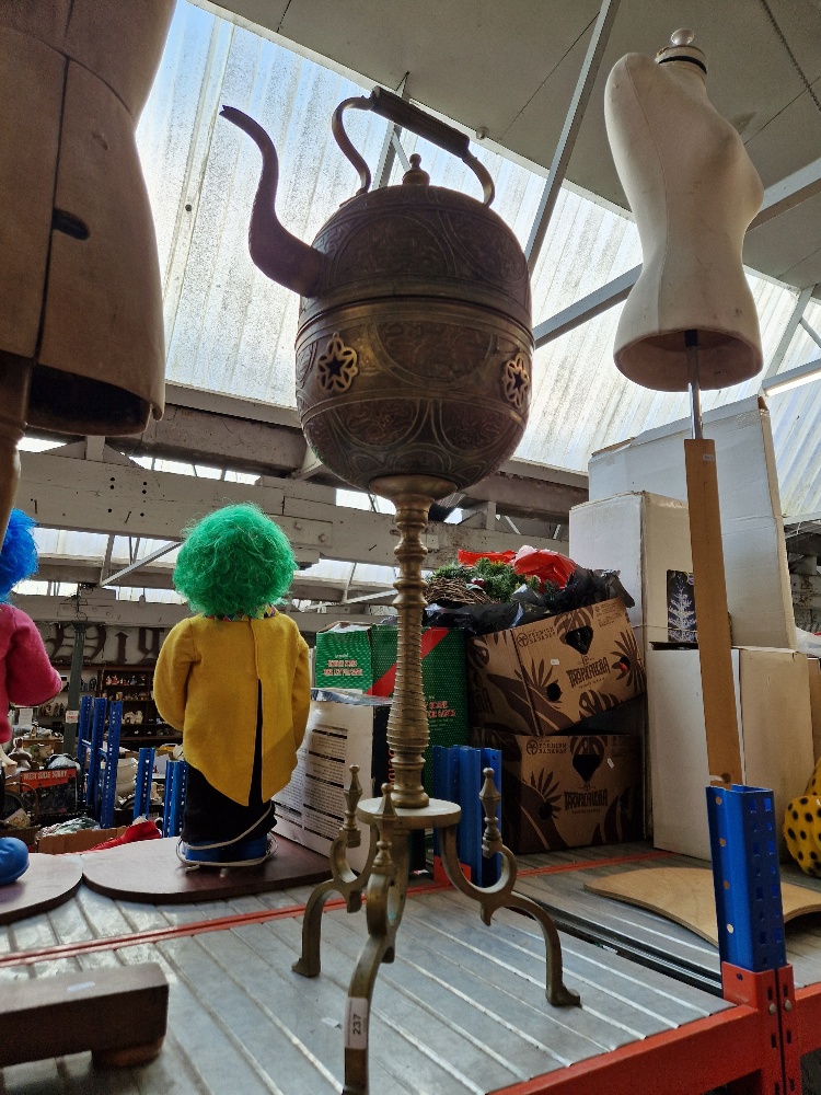 A large Eastern brass kettle on stand.