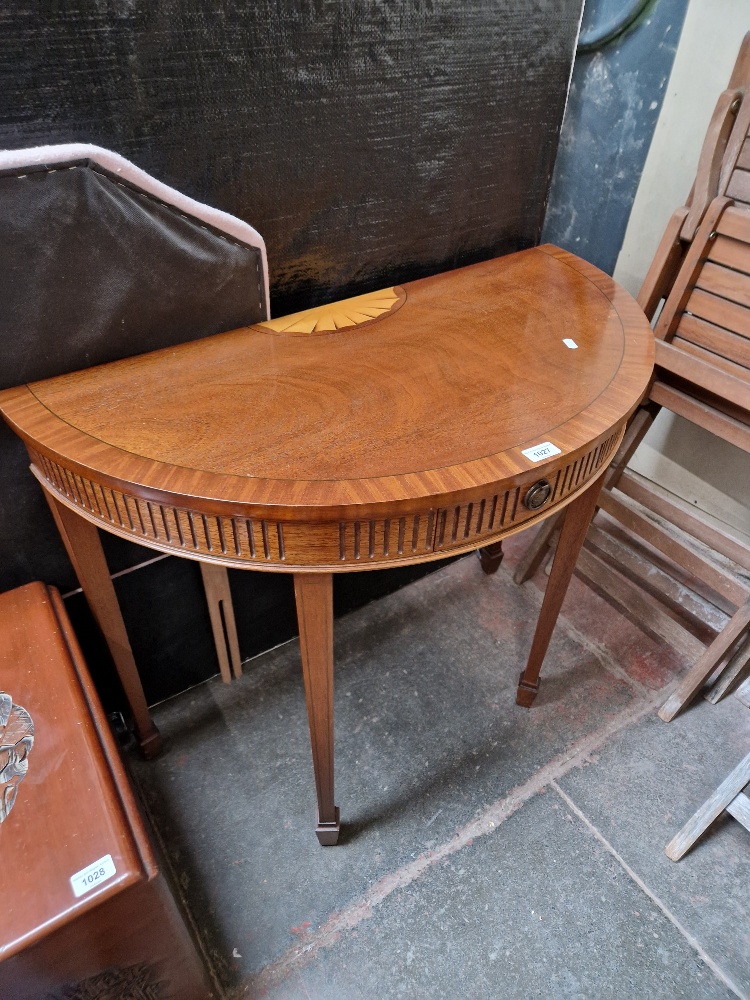 An Adam style inlaid mahogany demi lune table.