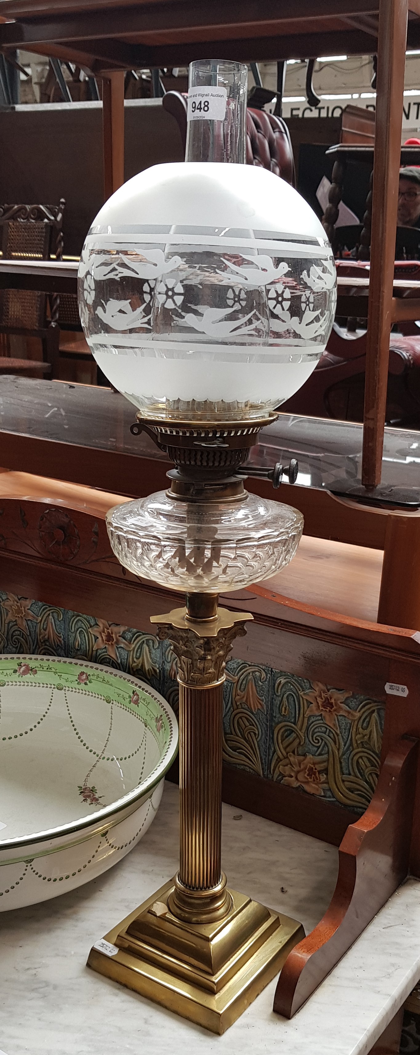 A brass and glass oil lamp with Corinthian column base.