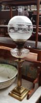 A brass and glass oil lamp with Corinthian column base.