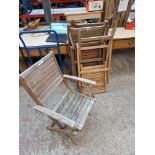 A set of four folding teak garden chairs.