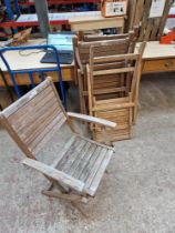 A set of four folding teak garden chairs.