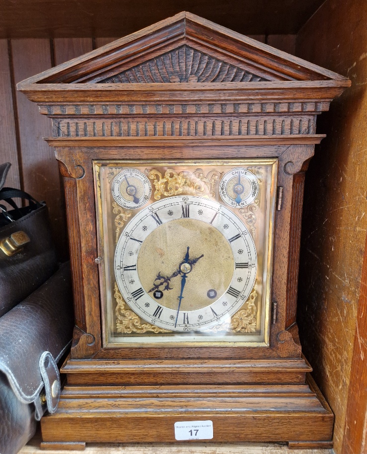 A oak architectural bracket clock with pendulum and key