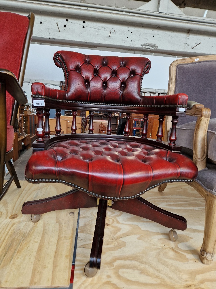 An oxblood red leather Chesterfield captain's chair.