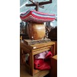 A red cow hide rug, a vintage stool, vintage solid wood table, a leather pouffe and a teak nest of