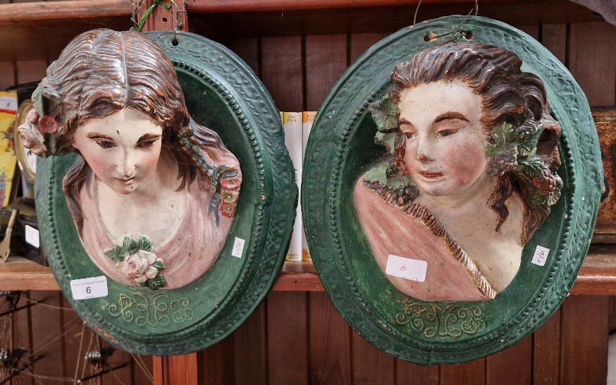 A pair of Victorian terracotta wall plaques featuring women's heads looking left and right