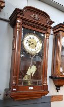 A German wall clock with pendulum and key.