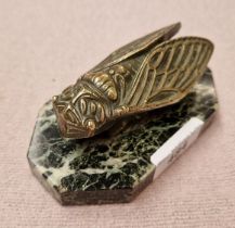 A novelty paperweight modelled as a bronze fly on marble base.