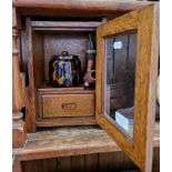 A smokers cabinet with tobacco jar, three pipes and a cutter/pricker.