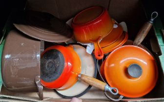 A box of Le Creuset pans and lids