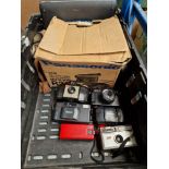 A box of cameras including Panasonic video camera and Kodak Brownie