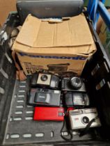 A box of cameras including Panasonic video camera and Kodak Brownie