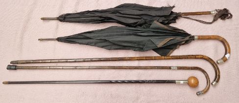 A bundle of 3 walking sticks and 2 umbrellas with silver tops/collars