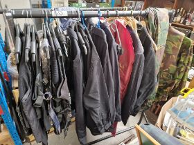 A collection of assorted cosplay items to include camoflage outfit, leather vests, pin stripe suit..