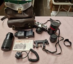 A Minolta 35mm camera with extra lenses and flashgun