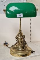 A green glass and brass angle desk lamp