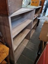 A pair of bookcase/shelving units together with a metal garden table.