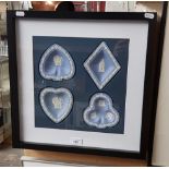 A framed display of blue and white Wedgwood jasperware.