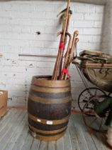 A stick stand barrel containing various walking sticks.