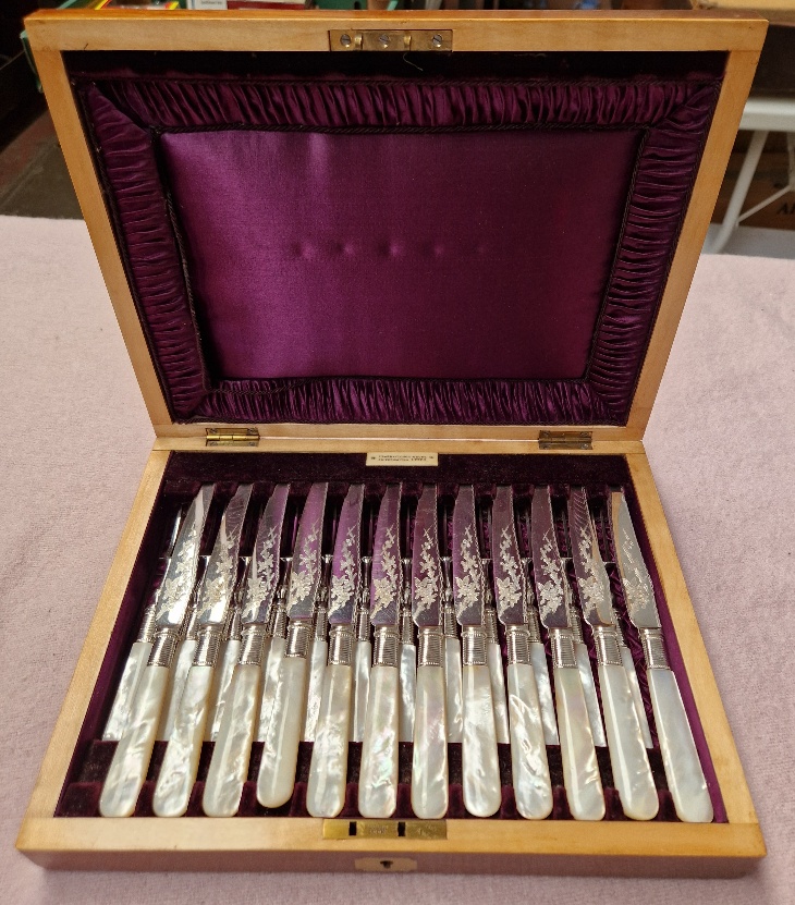A cased set of knives and forks, 12 settings, mother of pearl handles, box marked Barraclough &