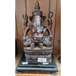 An Eastern bronze effect Ganesh figure on wooden base.