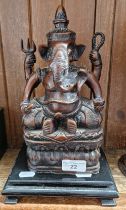 An Eastern bronze effect Ganesh figure on wooden base.