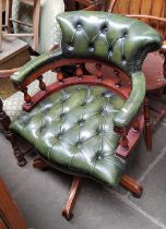 A green leather Chesterfield captain's chair.