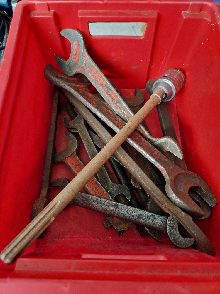 A red box of assorted heavy duty spanners and a boring tool