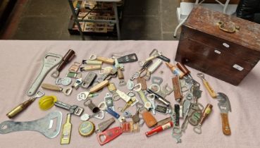 A collection of approximately 77 vintage bottle openers together with a wooden case.