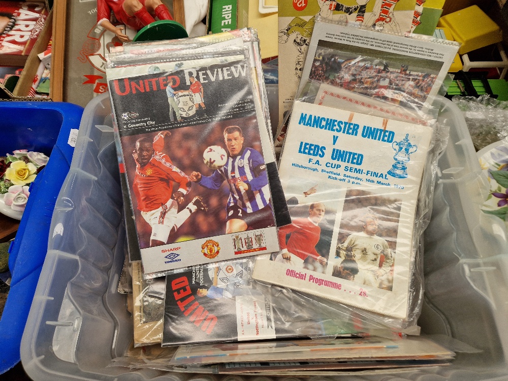 A box of Manchester United football programmes.