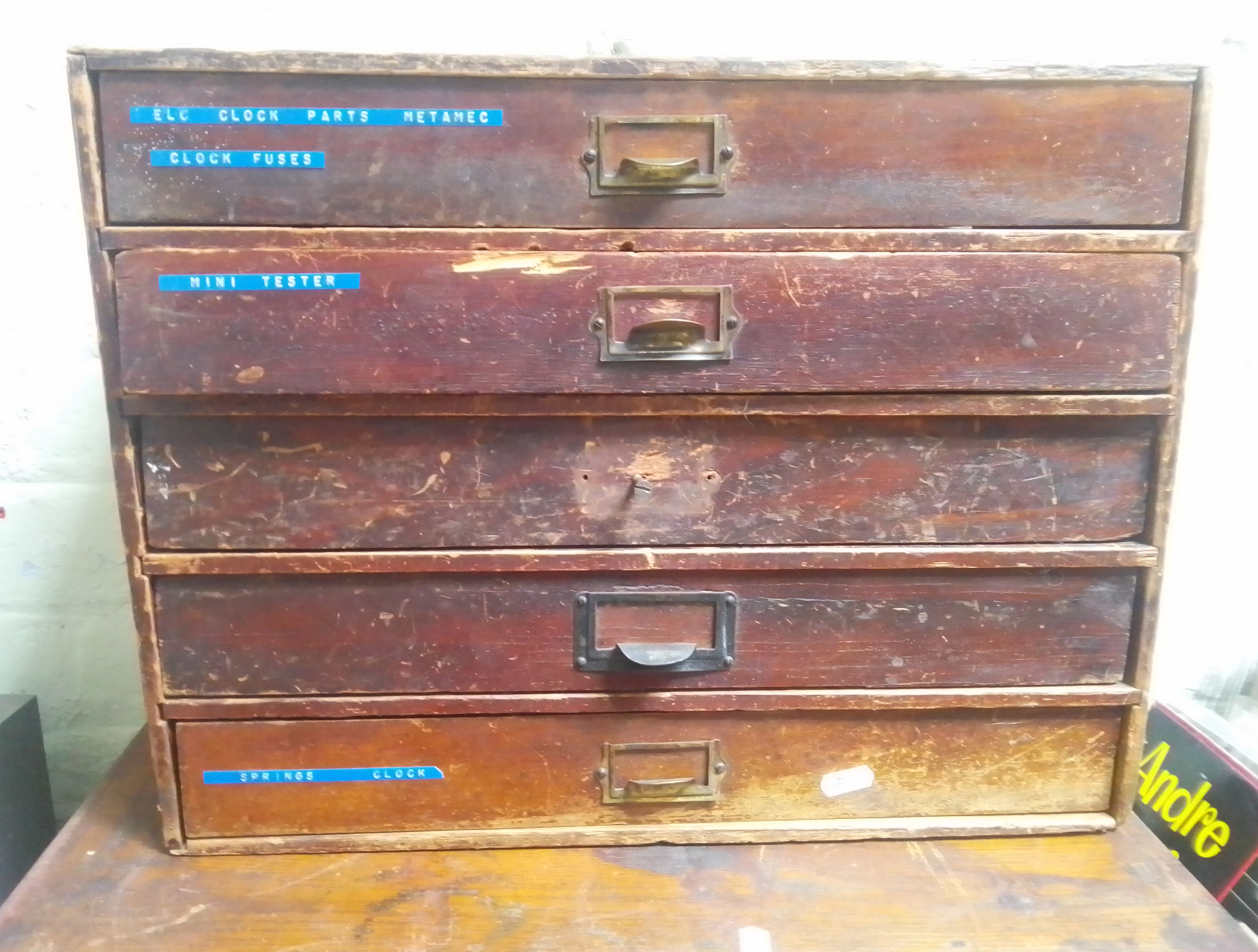 A five drawer horologist's chest and contents comprising watch and clock making spares.