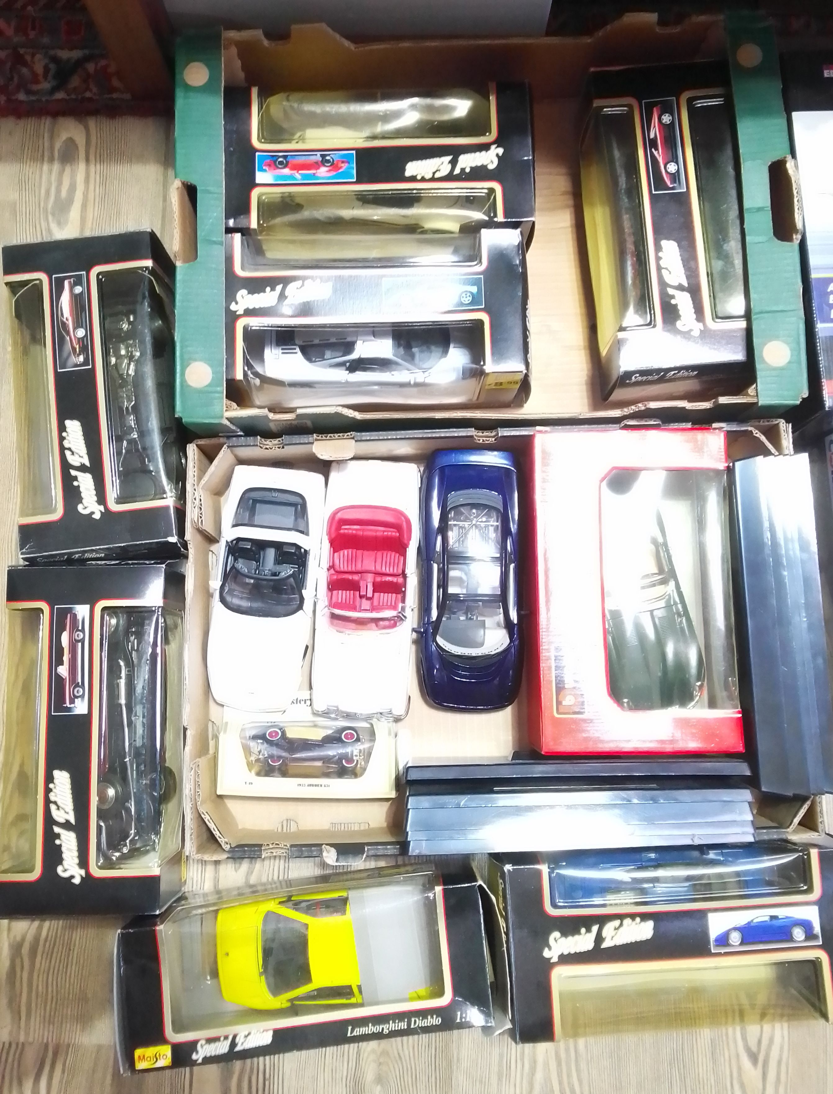 Two boxes of mainly die-cast vehciles including Burago and Maisto.