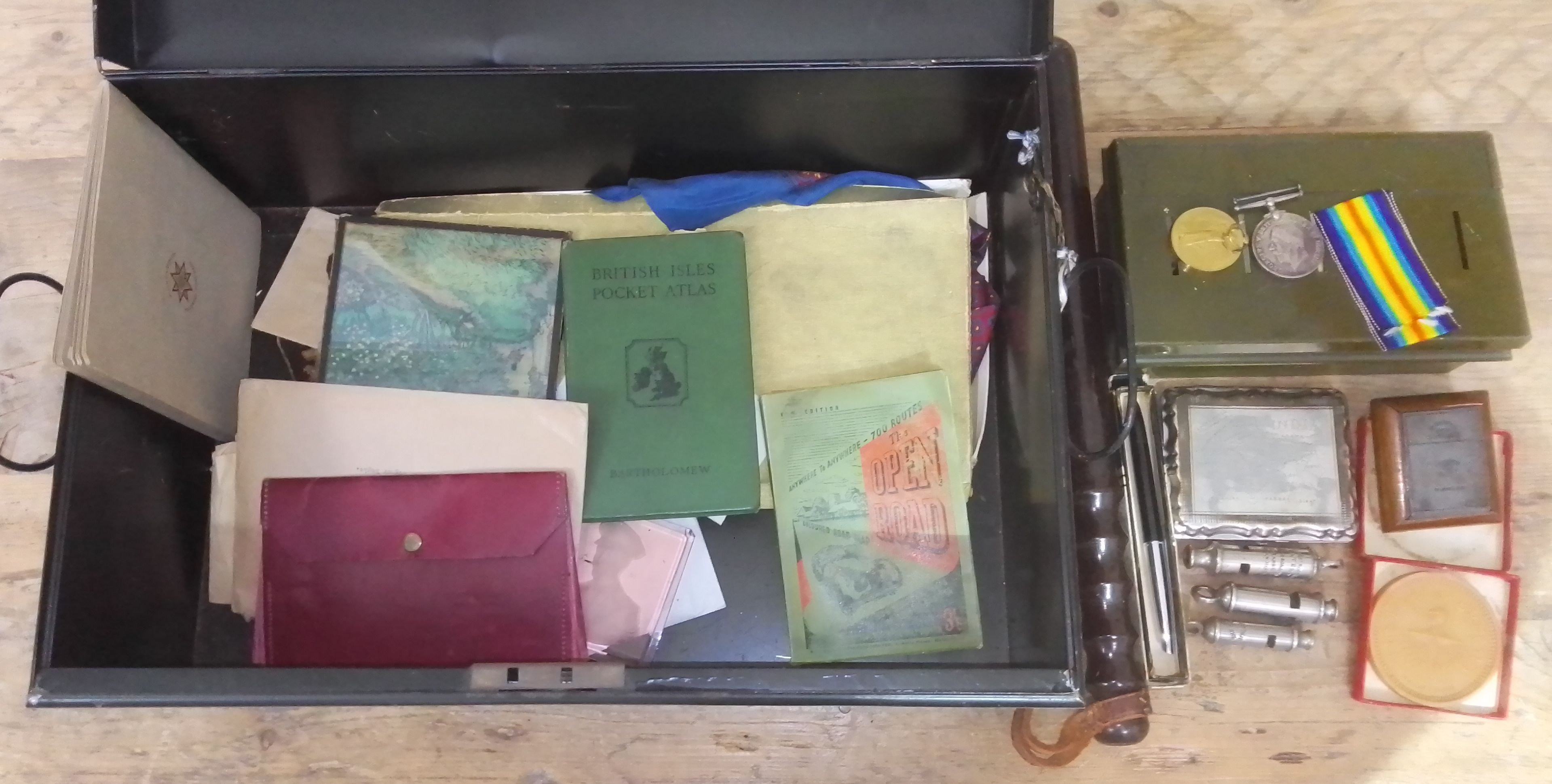 A tin of assorted militaria and collectables including a WWI pair, a truncheon, a Ransomes patent