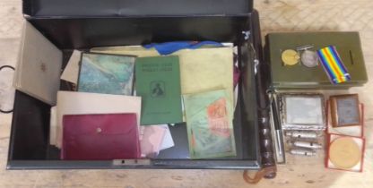 A tin of assorted militaria and collectables including a WWI pair, a truncheon, a Ransomes patent