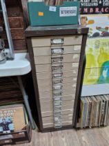 A 15 drawer triumph metal cabinet and contents comprising of clock making spares.