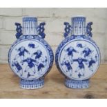 A pair of Chinese late 19th century blue and white porcelain moonflasks decorated with figures,