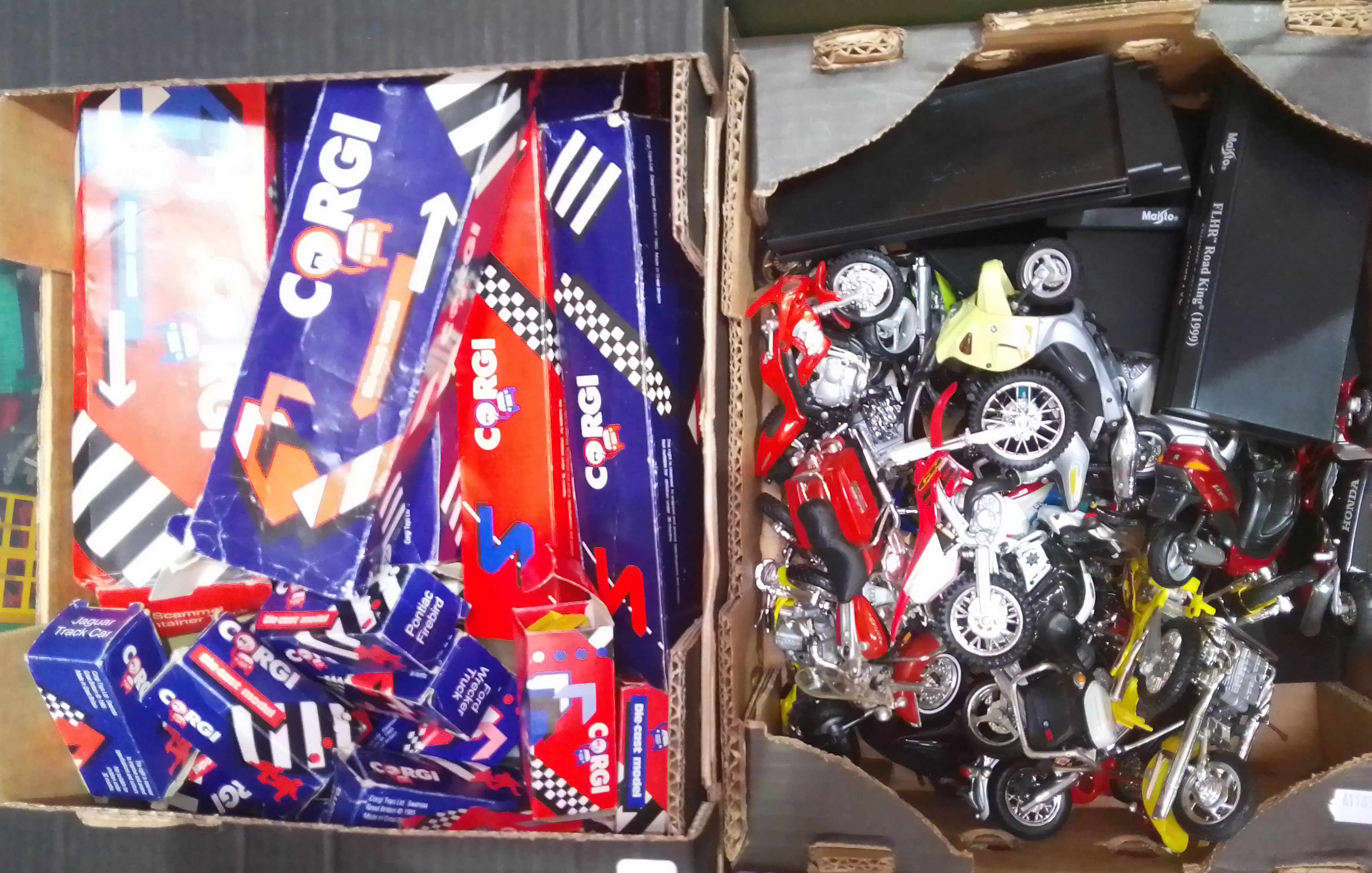 A box of Corgi die-cast vehicles and a box of model motorcycles.