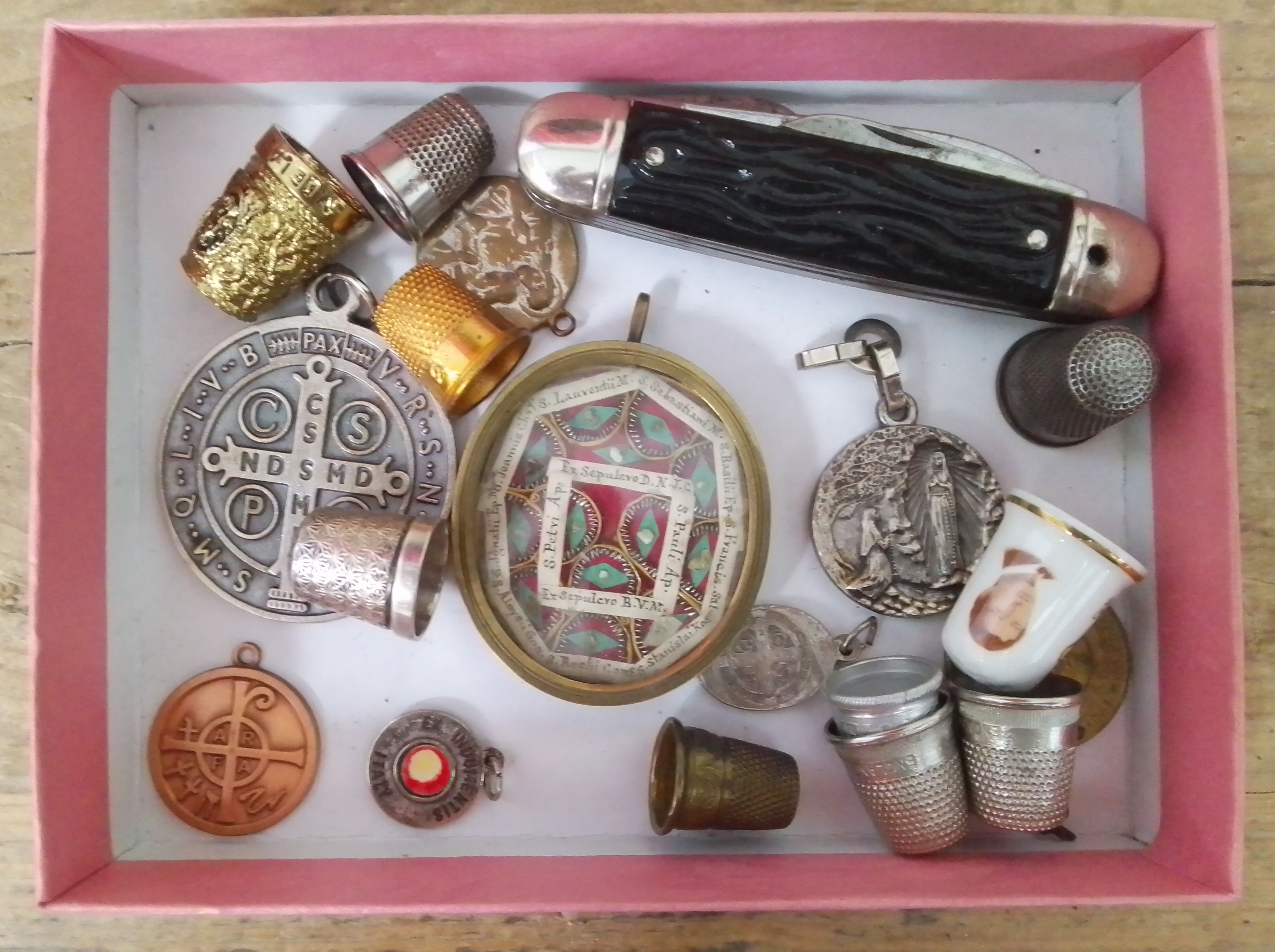 A brass framed collection of religious relics 5.5cm x 5cm, together with other collectables.