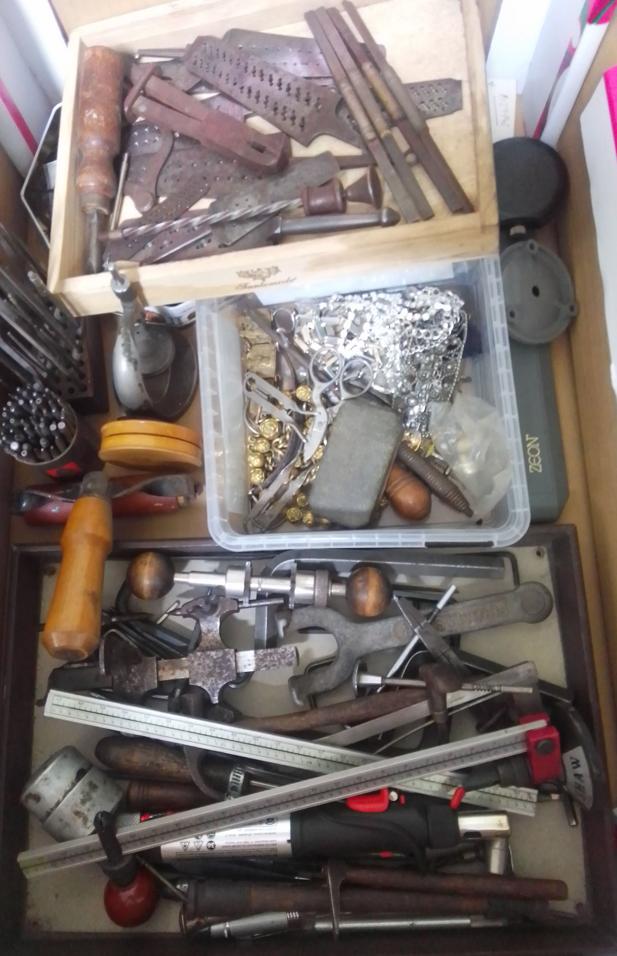 A box of mainly assorted horologist's spares and tools.