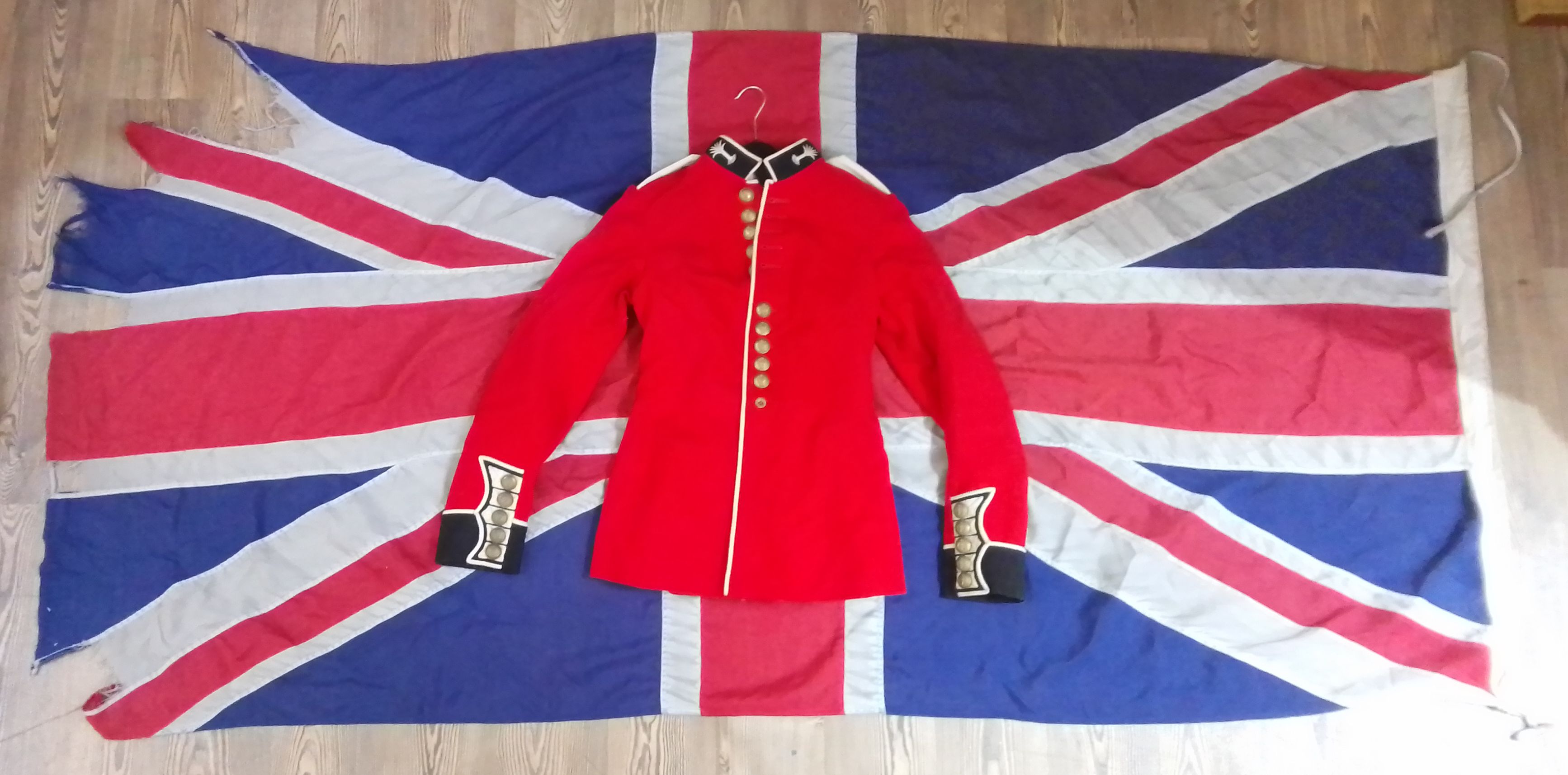 A vintage Union Jack ship's flag, 7&1/2ft x 3&1/2ft and a military dress jacket.