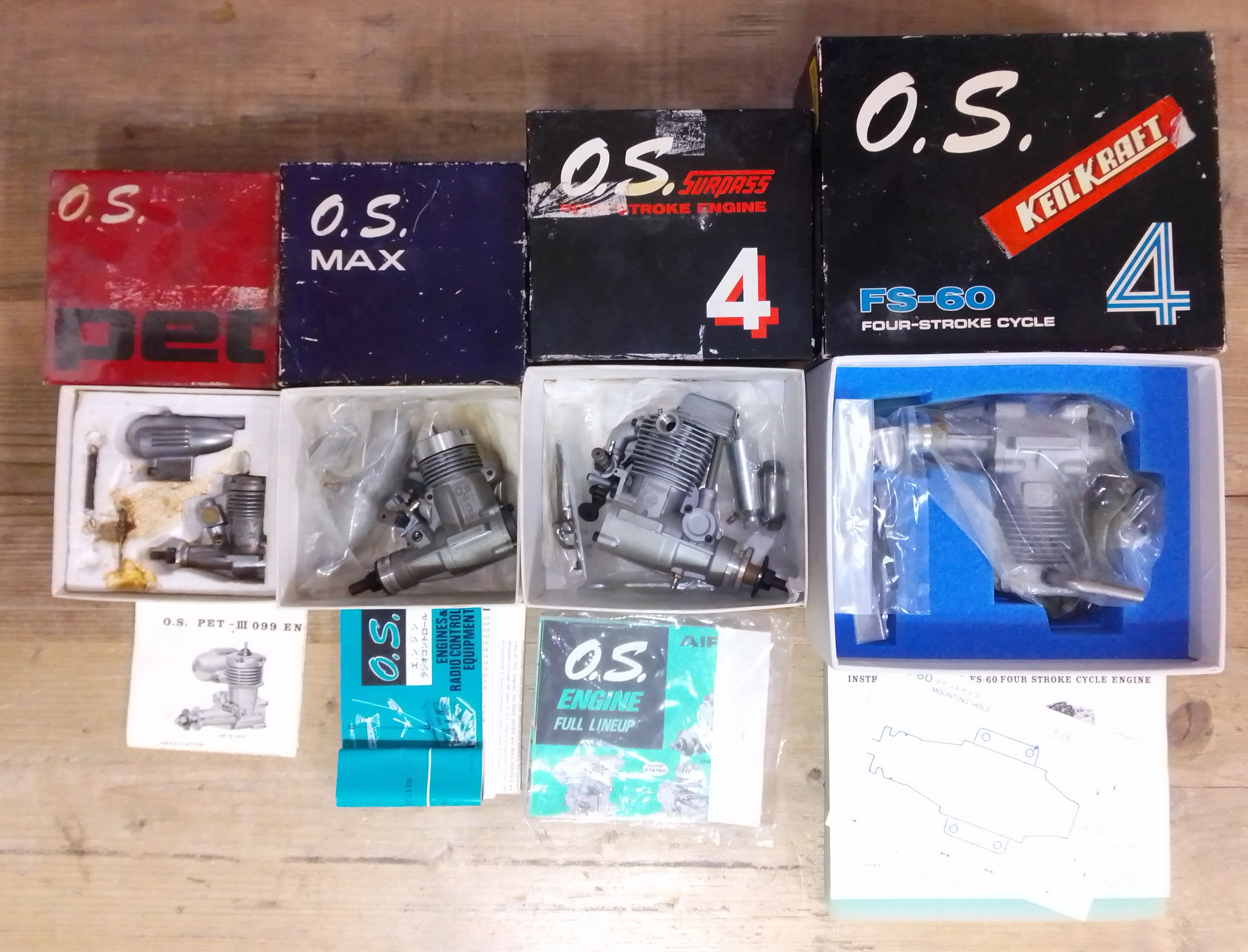 A group of four OS radio control model aeroplane engines comprising OS Pet, OS Max, OS Surpass and